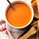 A serving of roasted tomato soup with toast alongside.