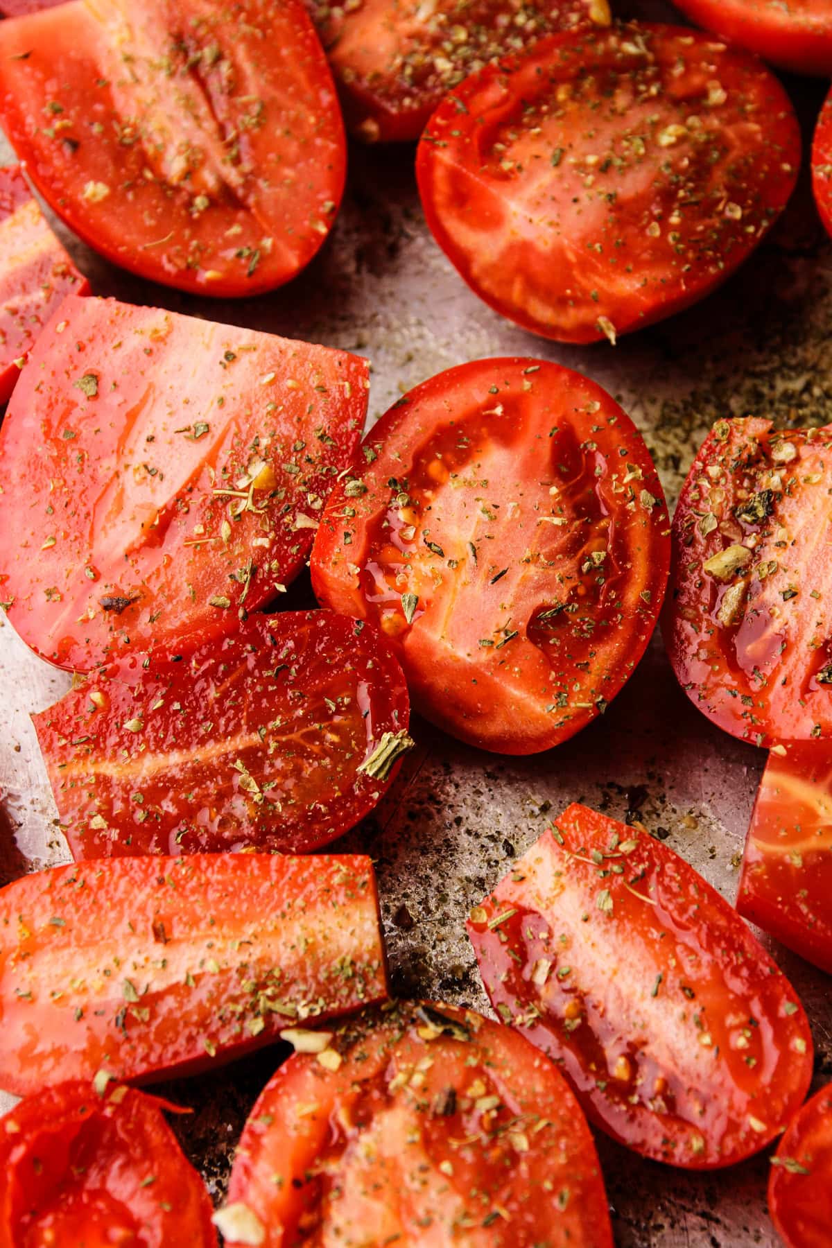 Roma tomatoes halved on a sheet pan.